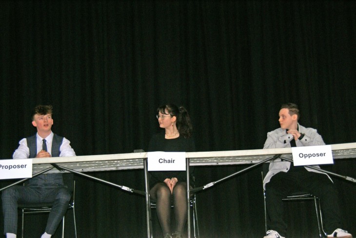 Theo K, Tara F and JJ J on stage for their debate